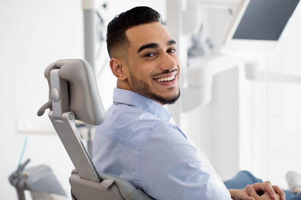 Smiling male patient at dental office for orthodontic treatment